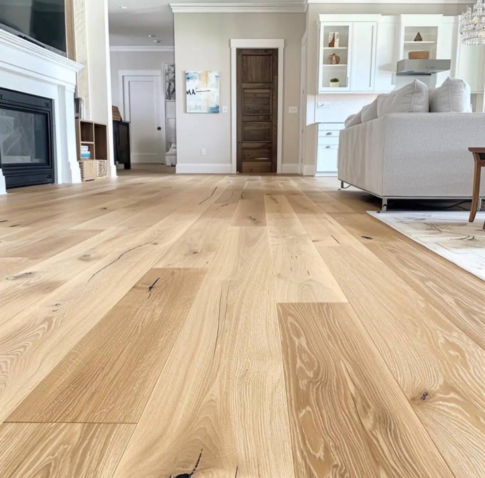 Light wide-plank hardwood flooring in a bright living room
